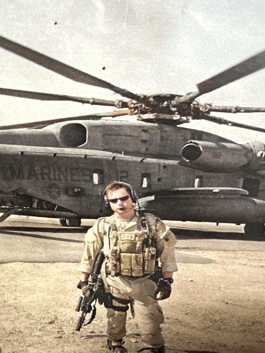 Shown in this photo is Marshman while he was on his deployment in Iraq. Marshman is standing in front of a Marine helicopter, in desert battle gear. When this photo was taken as well as who it was taken by is unknown.