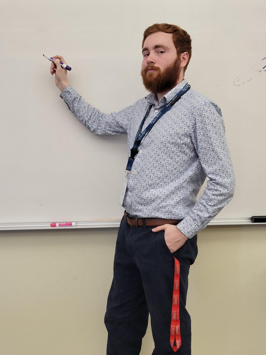 SRA teacher, Mr. Warlof standing in front of a whiteboard, ready to teach