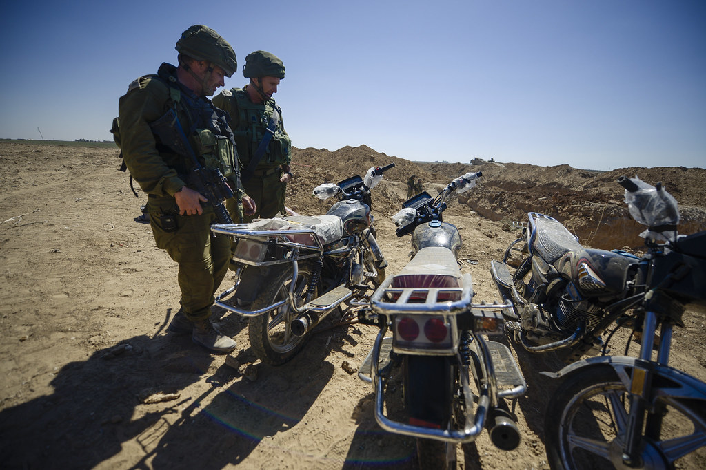 Members of the IDF looking down at motorcycles found in a tunnel on Israeli land. The motorcycles were used by Hamas most likely during an attack.