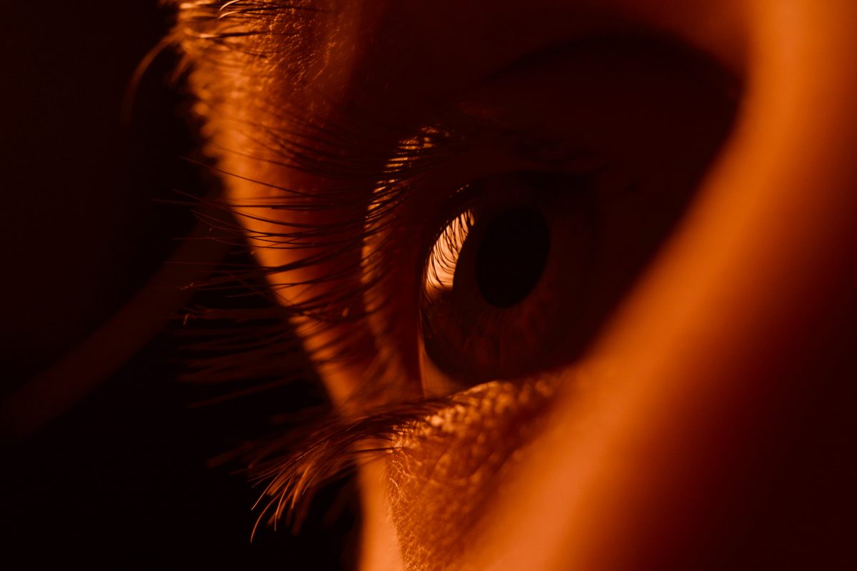 A+persons+eye+looks+outward.+Close-up+shot+of+eye+cloaked+in+orange+lighting.