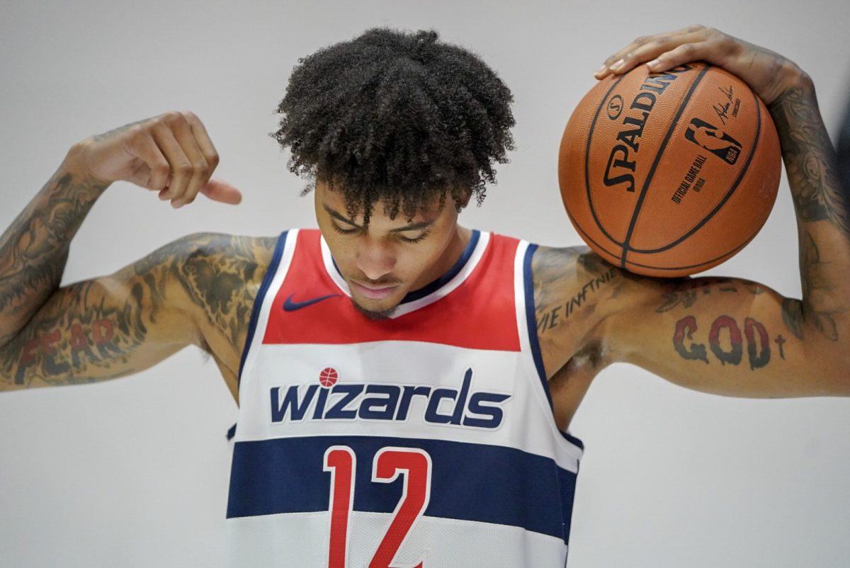 Kelly Oubre Jr. showing his new fear god tattoos for a picture. This tattoo was not banned but is an example of the tattoos players get.
