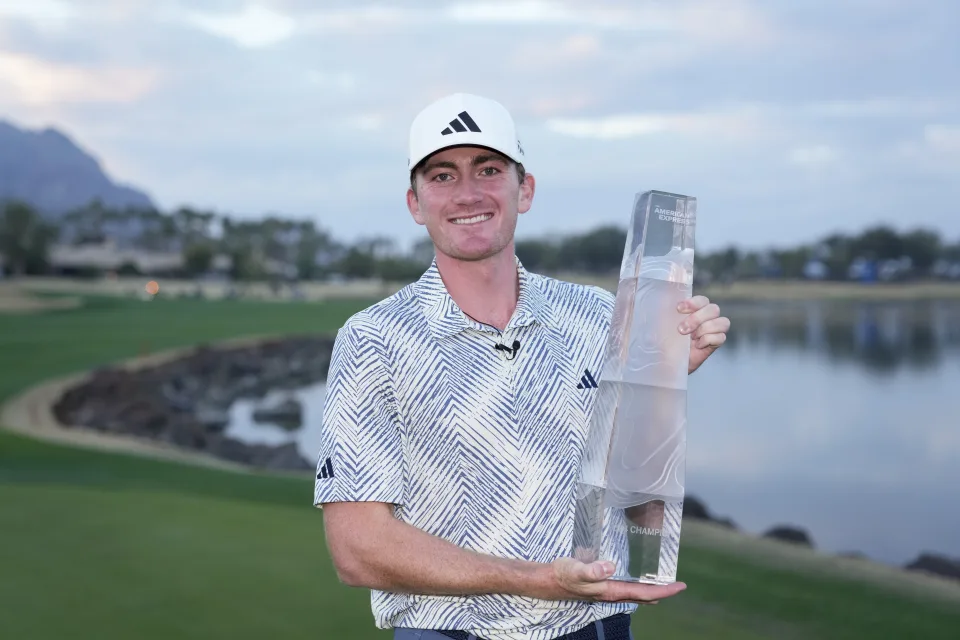 Nick Dunlap holds the trophy after winning the American Express golf tournament, Sunday, Jan. 21, 2024, in La Quinta, Calif.