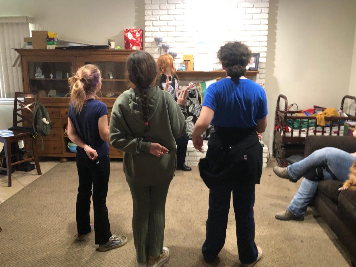 Four girls doing the Girl Scout promise. They do it before they start their meetings every meeting including the pledge of allegiance and the Girl Scout Law.