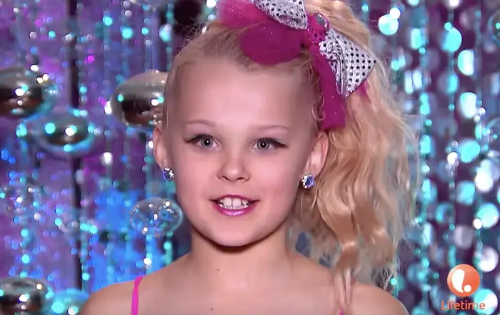 JoJo Siwa when she was a young star on Dance Moms. In this photo she is seen wearing her iconic bow.
