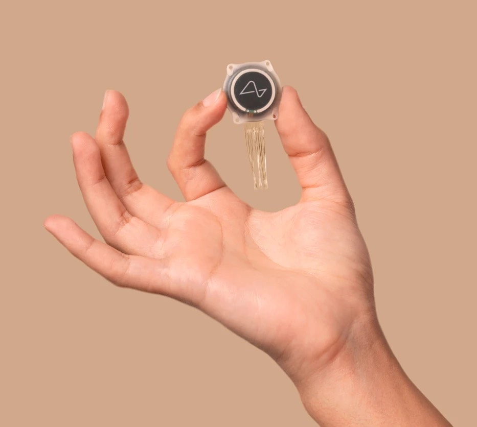 A clear image of someone holding the micro Neuralink chip. This photo gives an idea of how small the brain disk really is.