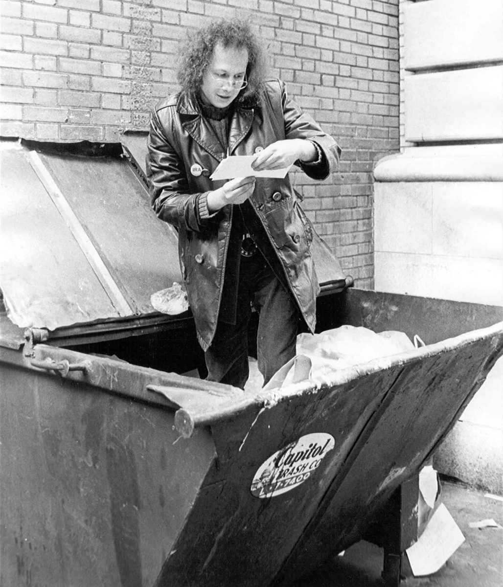 Guy looking through dumpster diving.