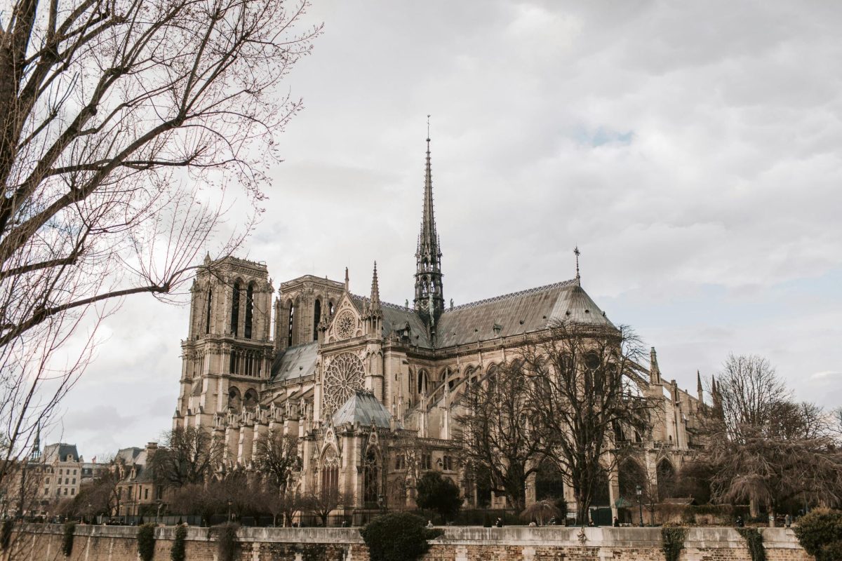 Taken just a little over a year before the destructive fire, the beautiful Notre Dame Cathedral stands around leafless trees on a cloudy day.