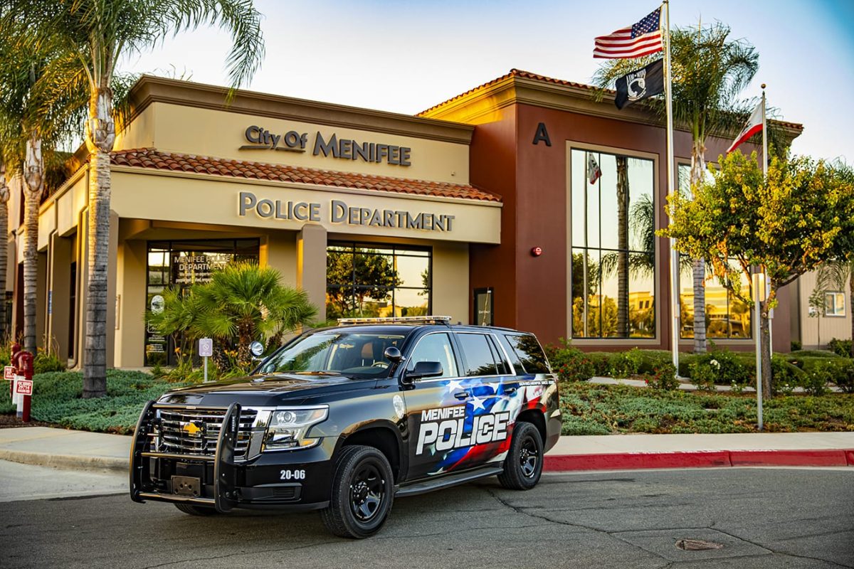 A front view of the Menifee police department, with a parked SUV in front of it.