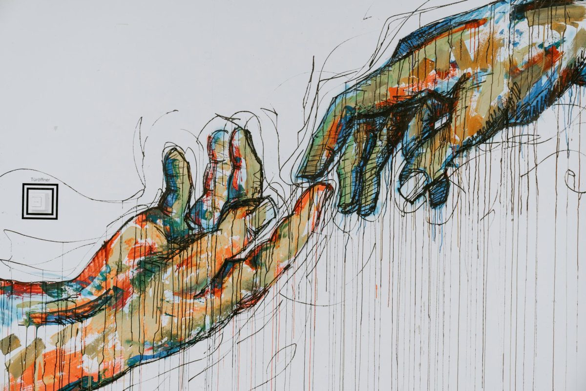 A painting of two human hands, used with ink sketching. Hands are reaching out to each other.